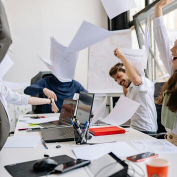 Gruppe wirft Papier ausgelassen in die Luft